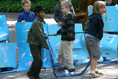 Die Kinder fischen während des Spiels mit Netzen symbolisch das Meer leer.